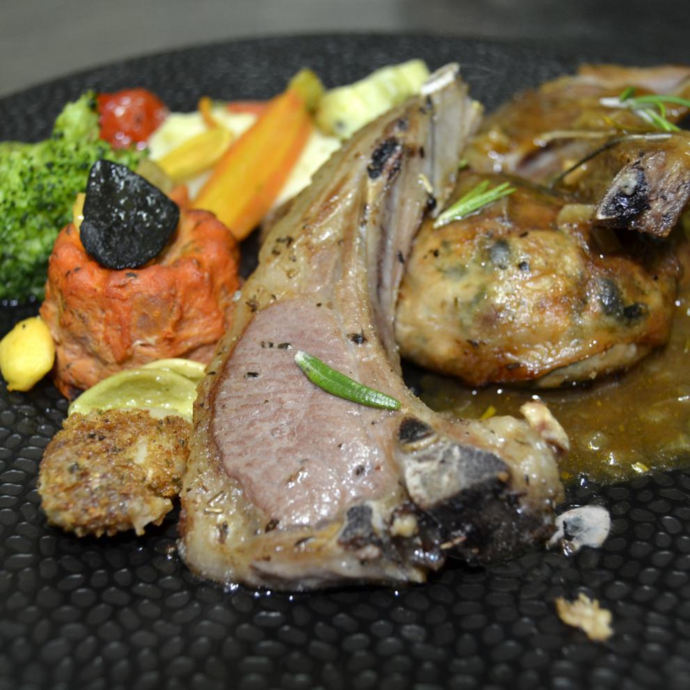 Crépinette de ris d’agneau et ses côtes, gousse d’ail en robe de pain, jus au romarin.